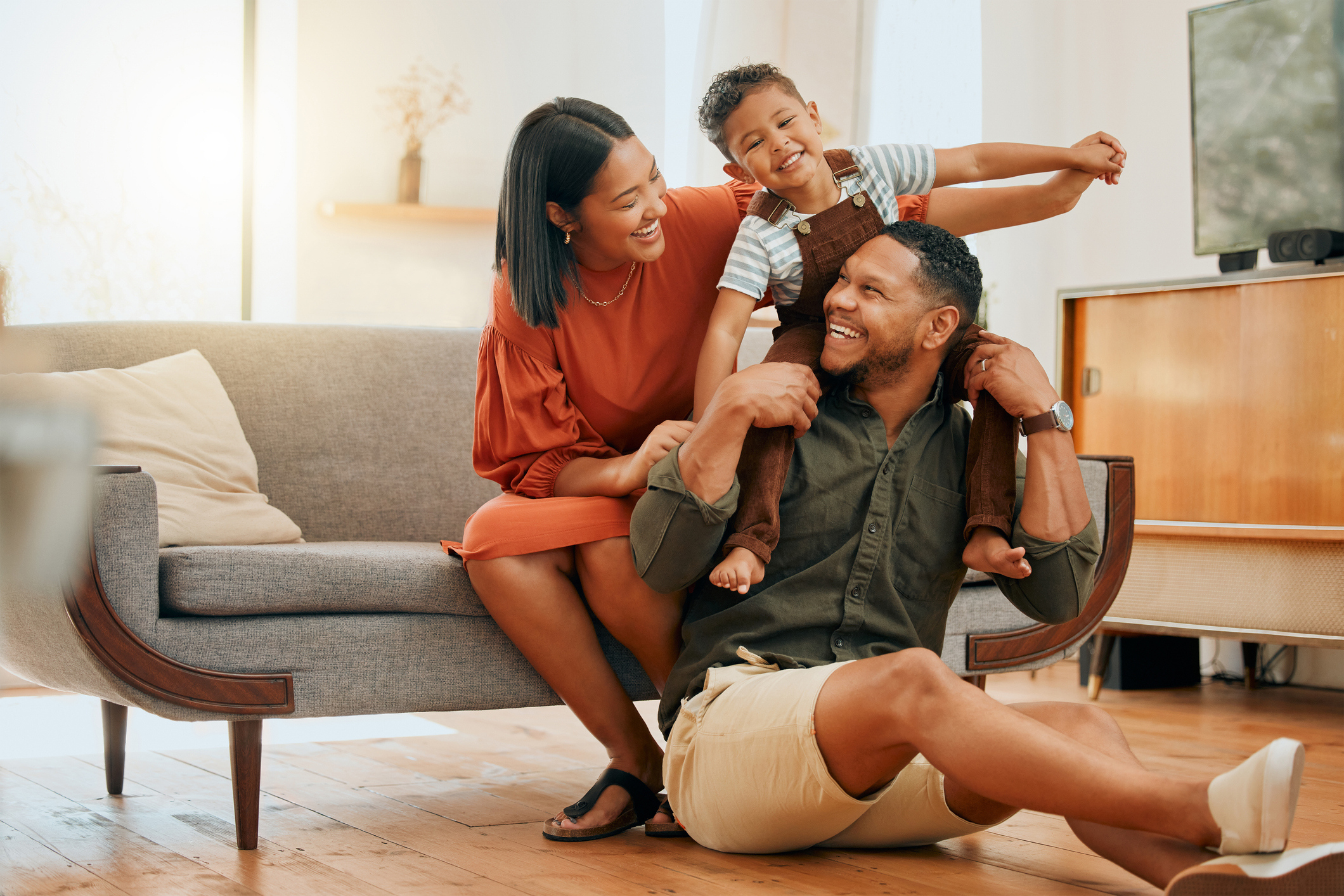 A happy family relaxing in their home and smiling at each other.